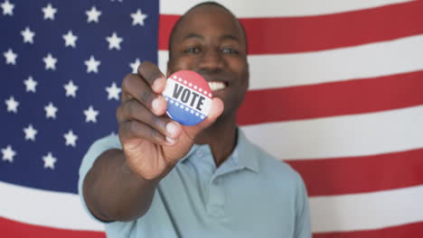 a young african american man proudly displays a voters badge