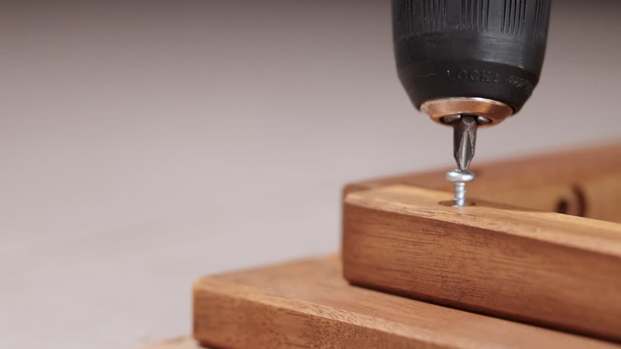 Close-up of a power drill assembling wooden furniture with precise screw placement, highlighting craftsmanship and efficiency