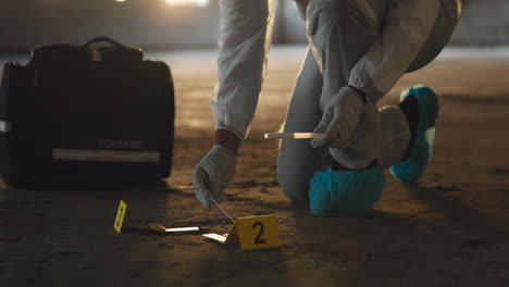 forensic investigator at crime scene collecting evidence