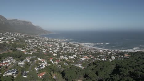 aerial view panning over south africa's camps bay on a sunny day.
