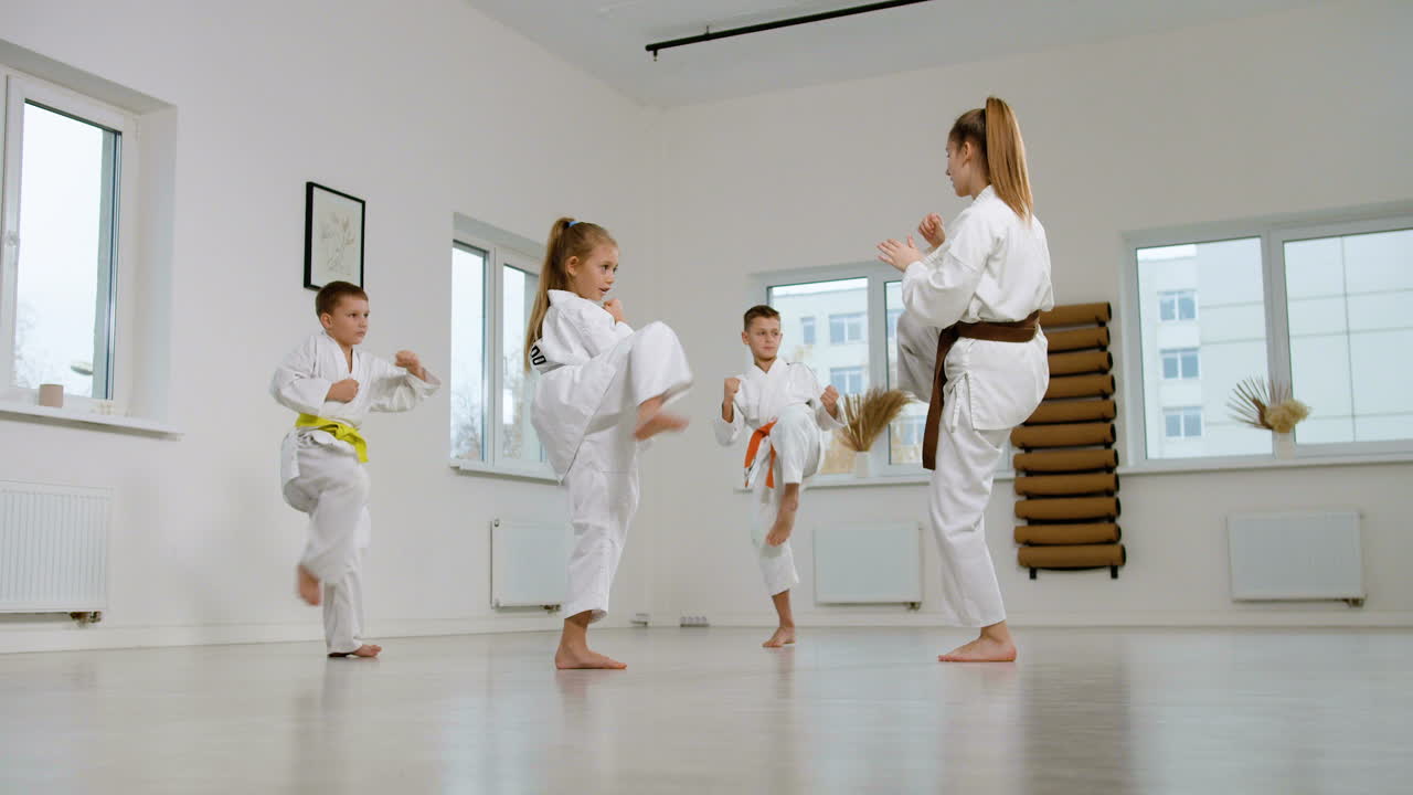 niños en kimono blanco en la clase de artes marciales