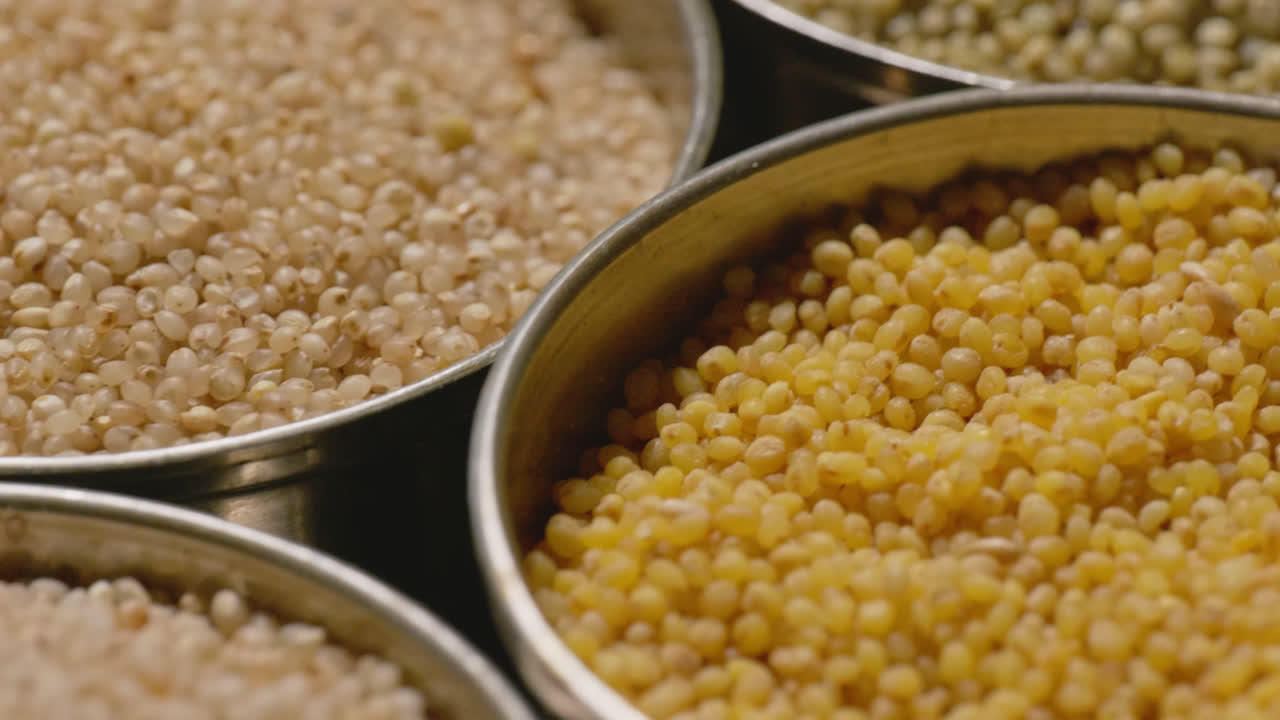 all types of healthy millet grains stored in the steel bowls, close up, parallax shot, 4k