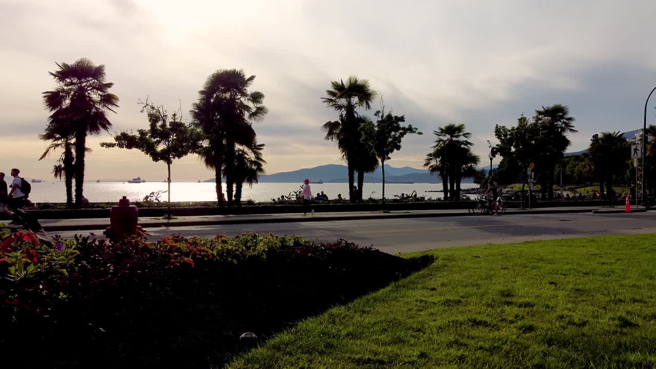 tropical beachside bike cyclist  skate boarders ebikes, unicycles fitness lanes dedicated to non gas powered vehicles by the beach on a beautiful sunset at English Bay Canada 1-3