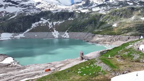 depósito de agua azul clara bajo una cadena montañosa de nieve y hielo