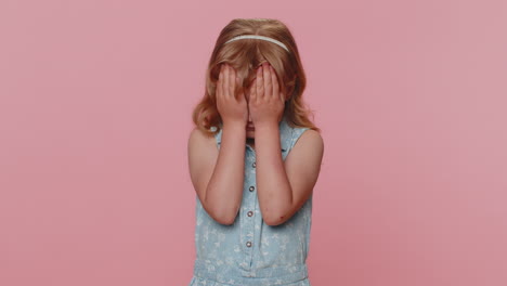 curiosa niña niña niño cerrando los ojos con la mano y espiando a través de los dedos, escondiéndose y mirando