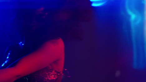 close-up van een jonge vrouw in een nachtclub bar of disco dansen met fonkelende lichten 7