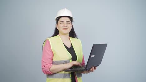 Engineer-holding-laptop-laughing-at-camera.