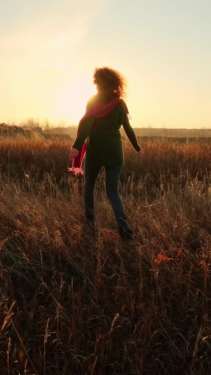 mujer disfrutando de una puesta de sol en un campo