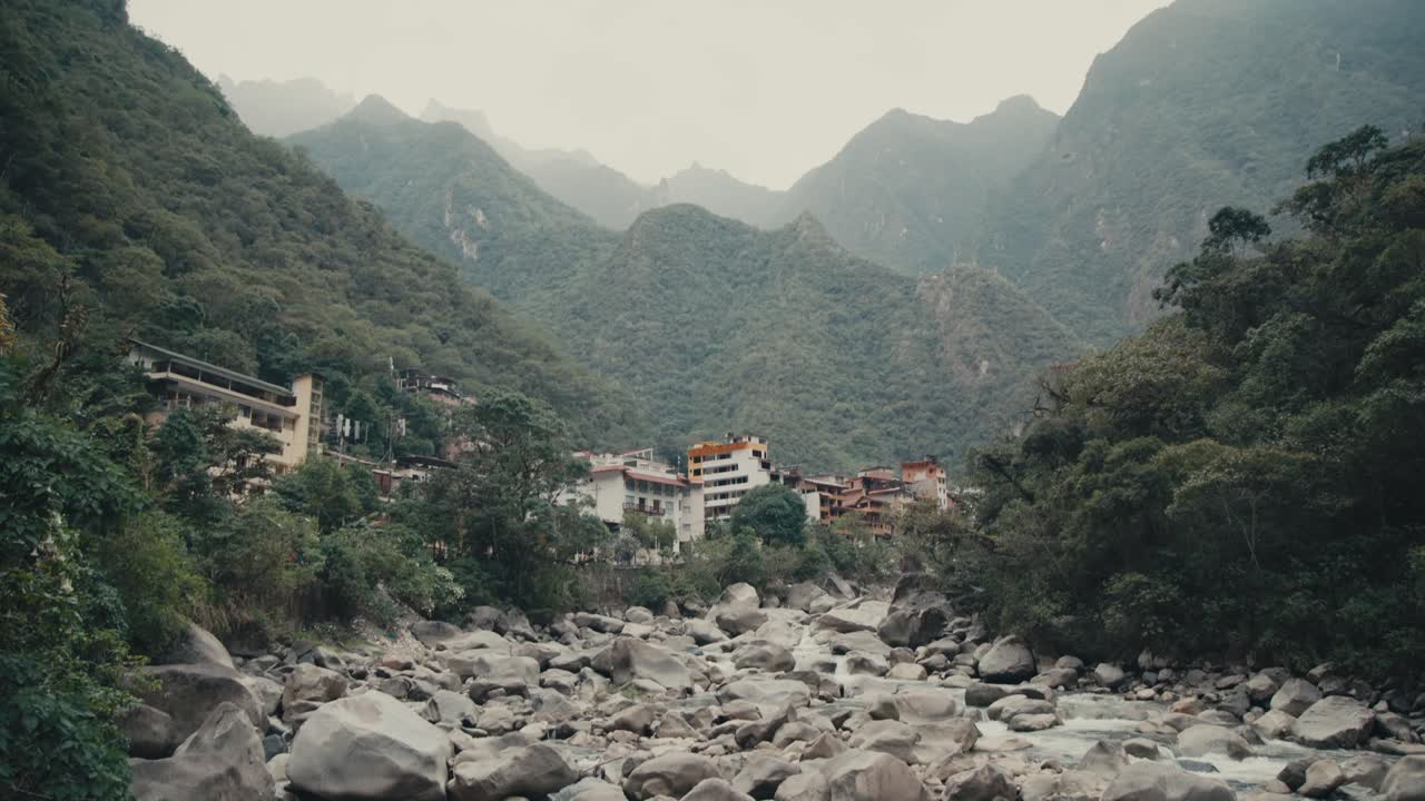 A Breathtaking View of Machu Picchu, Aguas Calientes City, and the Urubamba River in Peru - Pan Up Shot