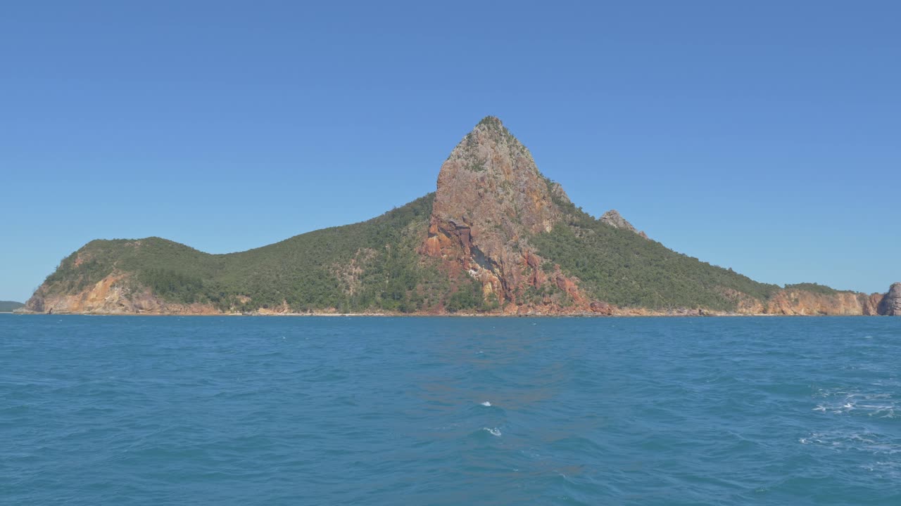 vista lejana de la isla de pentecostés en medio del agua azul del mar de coral en whitsundays, qld, australia del norte