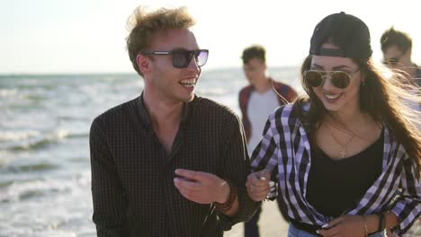 couple walking and talking, laughing happy, joyful and playful, enjoying nature landscape by the beach. slowmotion shot