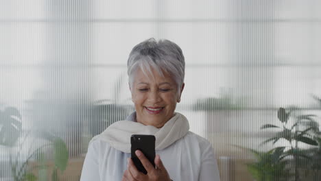Retrato-Feliz-Mujer-De-Negocios-India-De-Mediana-Edad-Usando-Un-Teléfono-Inteligente-En-La-Oficina-Disfrutando-Leyendo-Mensajes-Navegando-Mensajes-De-Texto-En-Línea-En-Un-Teléfono-Móvil-Sonriendo-Satisfacción