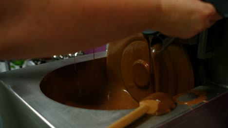 worker filling mould with melted chocolate