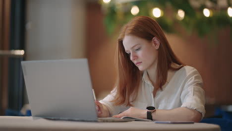 young female student is educating remotely by internet viewing lecture online on laptop display