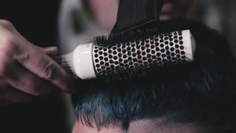 secado por soplado de cabello masculino corto en la barbería
