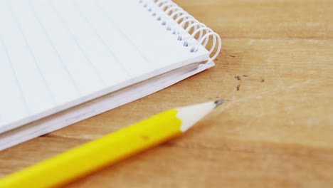 notepad and pencil on wooden plank