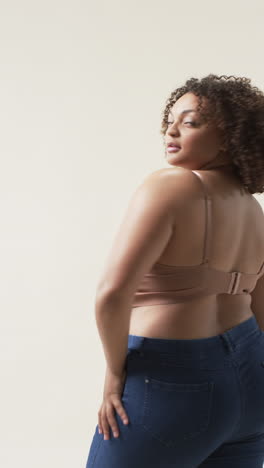 vertical video: confident plus size woman posing , embracing body positivity in casual attire