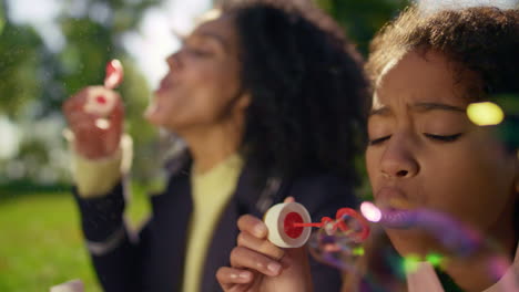 Curly-girl-blowing-soap-colorful-bubbles-closeup.-Carefree-childhood-moments.