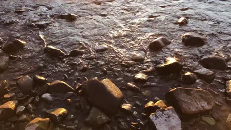 Wasser-Spült-Bei-Sonnenuntergang-über-Felsen-An-Der-Küste,-Mittlere-Aufnahme