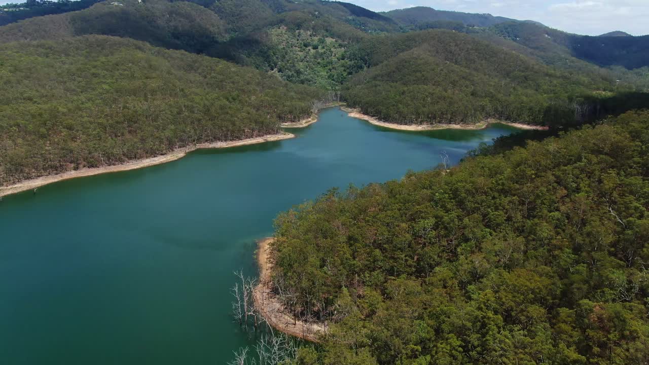 Flying over inlet of Advancetown Lake, native bush-land,view to Gold Coast hinterland
