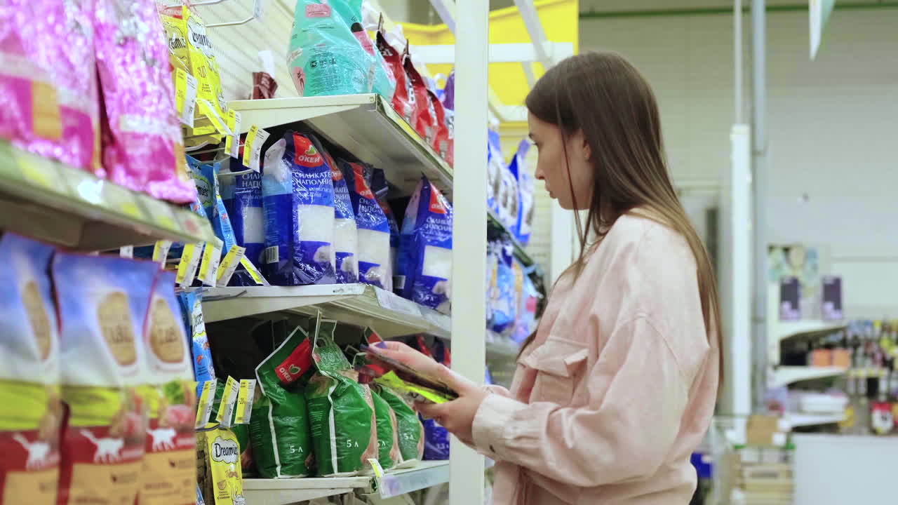 mujer comprando comida para mascotas en una tienda de comestibles
