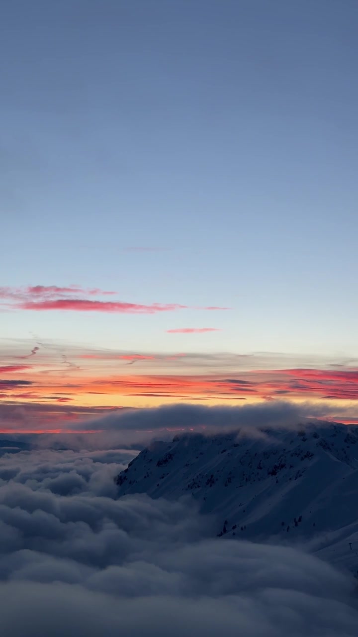 Vista verticale di un cielo nuvoloso attraverso il cielo colorato al tramonto sulla Val di Fiemme in Trentino-Alto Adige, Italia. Ripresa panoramica.
