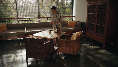 boy walking preparing tea in villa hotel semi outdoor sunny backlight