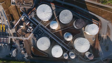 top down aerial of fuel tanker truckers filling with chemicals and gasoline, diesel, gas