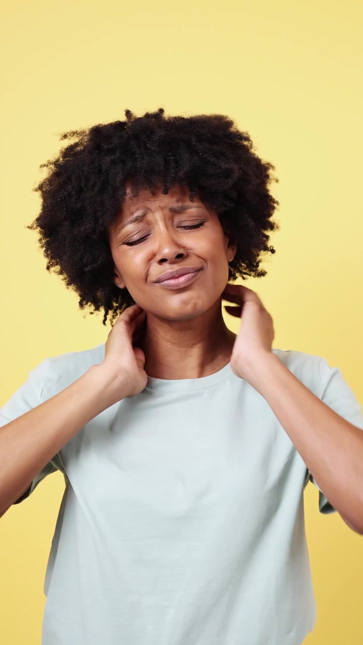 Giovane donna afroamericana che soffre di dolore al collo