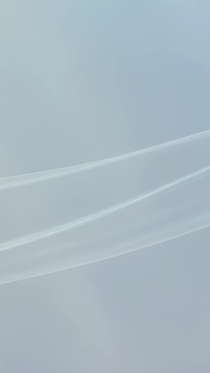 Vertical video: Starting animation, translucent ribbon shifting upward as pale blue phone wallpaper