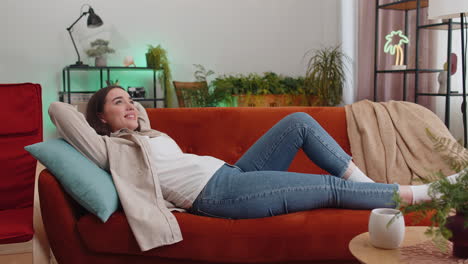 Tired lazy woman enjoy relaxing on home sofa resting napping after hard working day, closed her eyes