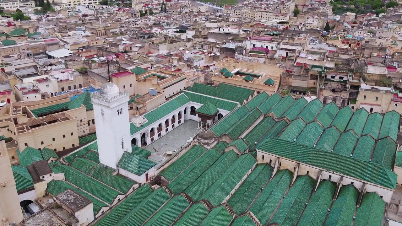 Vista aerea con drone della Moschea Al Quaraouiyine con tetti verdi e minareto bianco circondata dalla storica Medina di Fez, Marocco, ideale per progetti culturali.