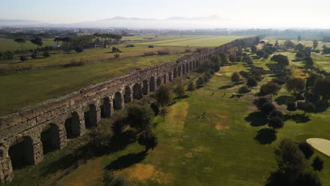 cinematic aerial view of ancient roman aqueduct on typical day in rome, italy