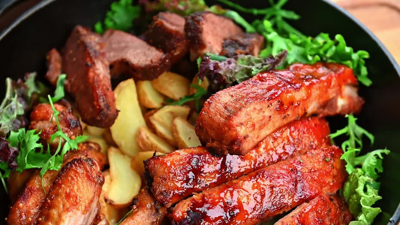 Deliziosa carne con patate servita su un piatto con verdure fresche. Piatti di carne e patate arrosto sono disposti su un piatto con insalata verde.