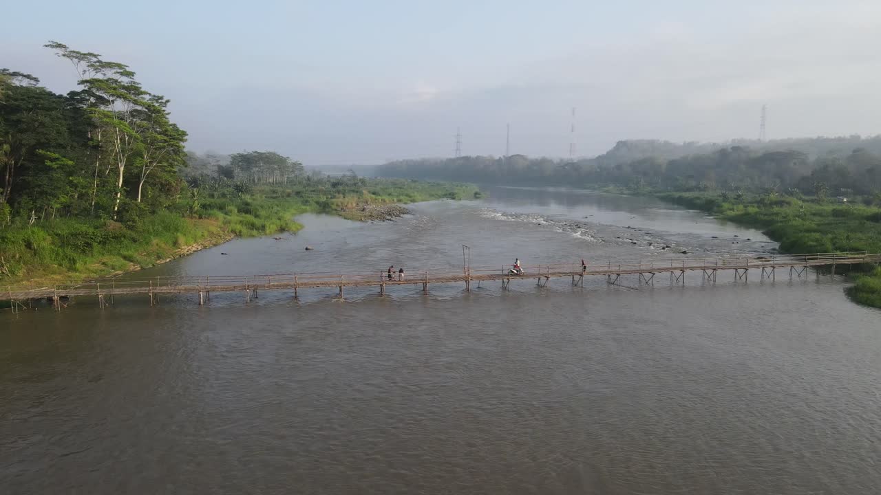 Aerial footage shows a wooden bridge spanning the Progo River, passable by motorbikes. As a link between the villages of Bantul and Kulonprogo.