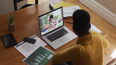 African-american-female-teacher-using-laptop-on-video-call-with-schoolgirl