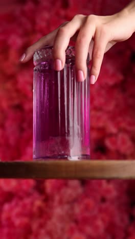 woman's hand holding a purple cocktail