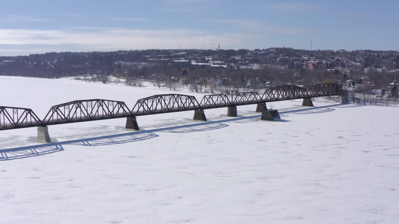 AERIAL: Moving Forward Over Walking Bridge In Fredericton On Sunny Winter Day