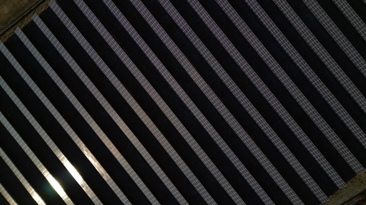Large grid of photovoltaic solar panels, producing green electricity for sustainability and eco friendly power. vertical bird's eye view drone Spectacular aerial view drone camera pointing down