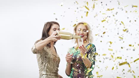 friends drinking champagne under shower of confetti