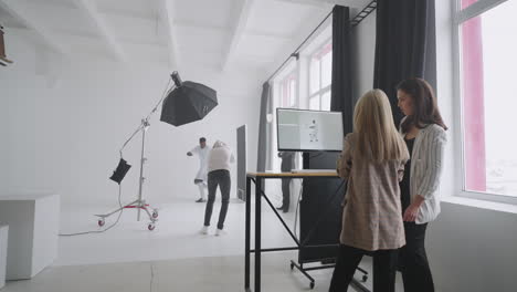 professional photo shooting of football player in studio editor and manager are choosing picture