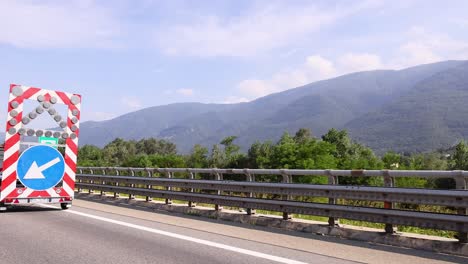 workers setting up road signs on highway