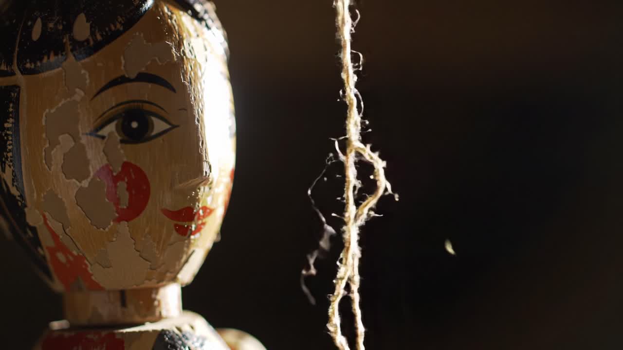 Studio ravvicinato di una bambola di legno realizzata ad arte, illuminata in modo affascinante da una luce soffusa, che enfatizza la sua espressione vivida e i dettagli intricati del design