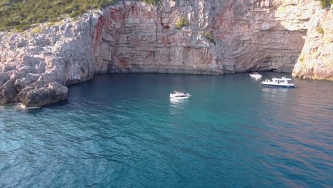 Vista-Aérea-De-Un-Pequeño-Bote-Rodeado-De-Agua-Turquesa-Y-Hermoso-Paisaje-Montañoso-En-Montenegro