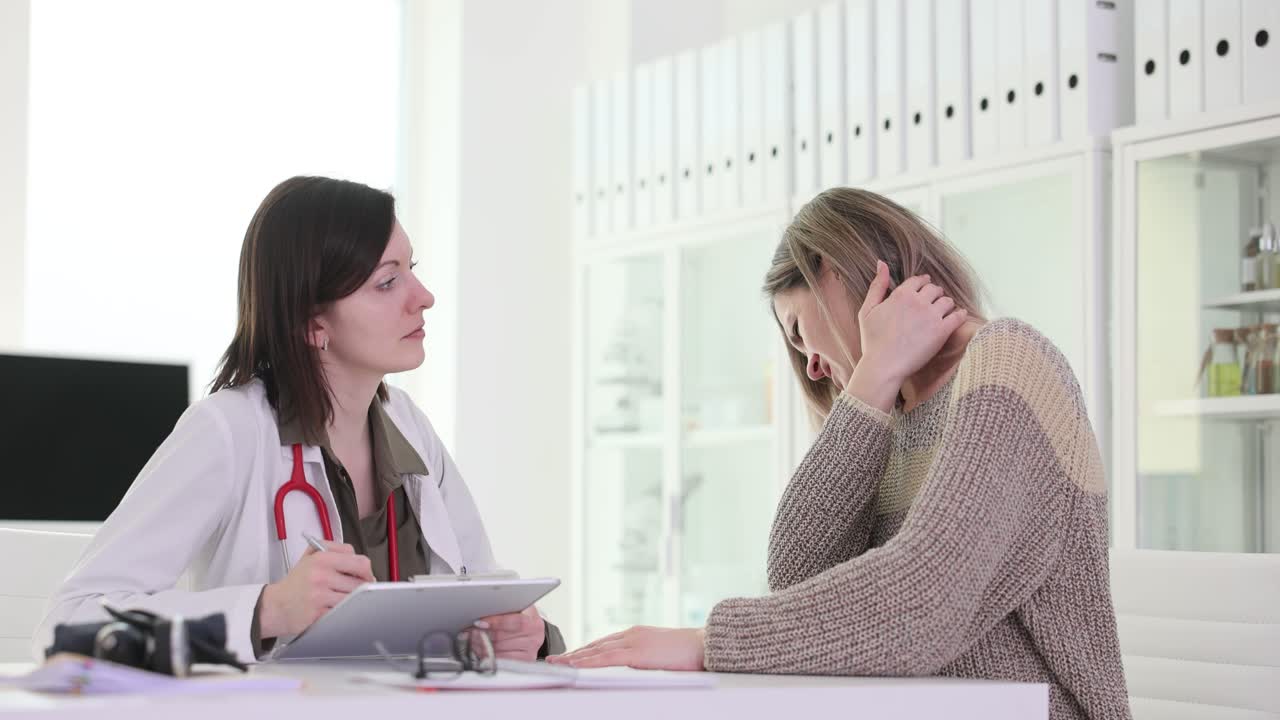 Doctor consulting with patient about neck pain