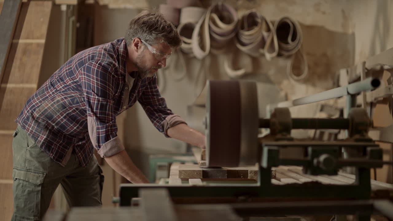carpintero lijando madera en el taller