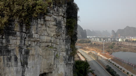 rock climber ascending karst mountain cliff outside yangshuo city, china, aerial