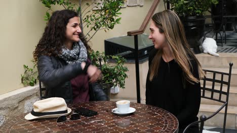 excited girlfriends hugging at a coffee place after not seeing each other for a long time