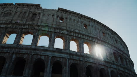 sun shines through colosseum arches rome