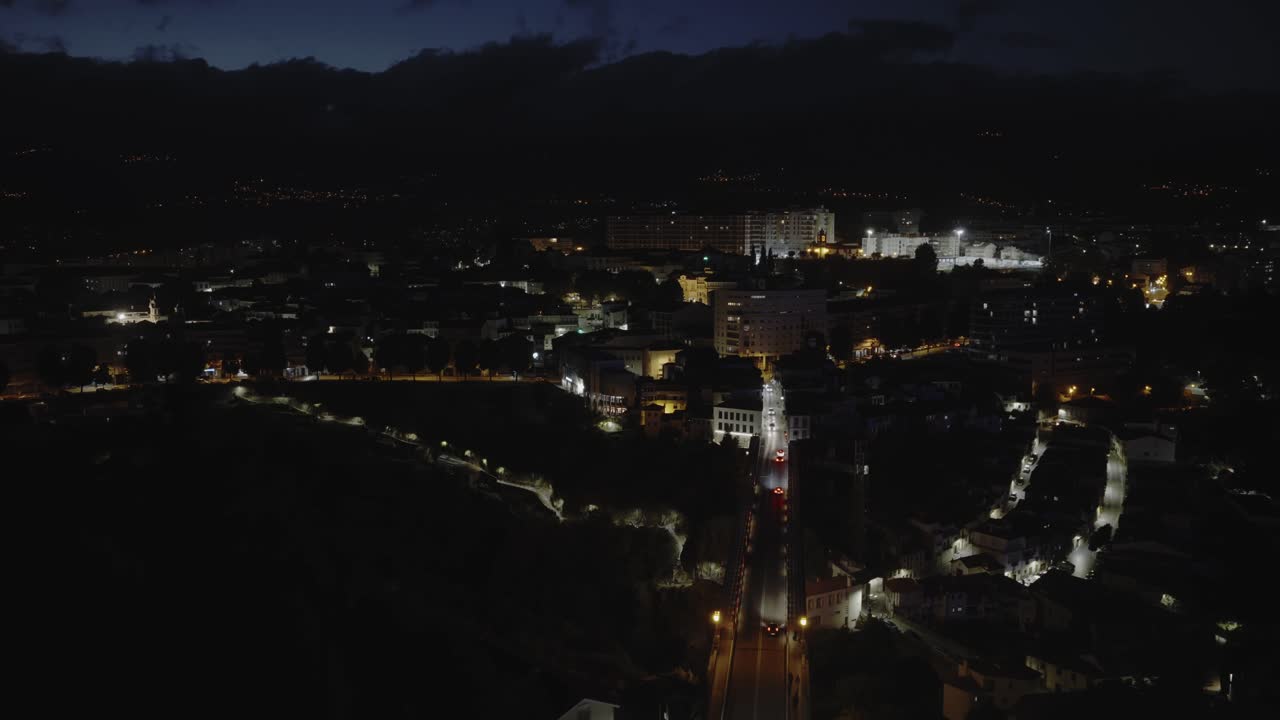 Ponte e auto nel mezzo di una città di notte